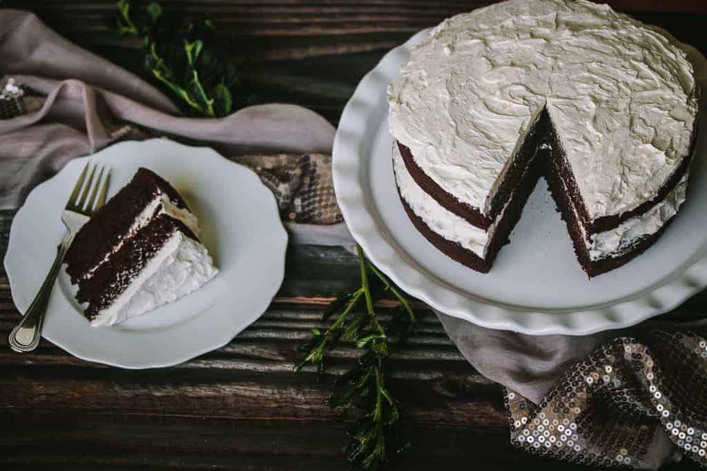 gluten free chocolate cake on a cake stand with a slice on a plate