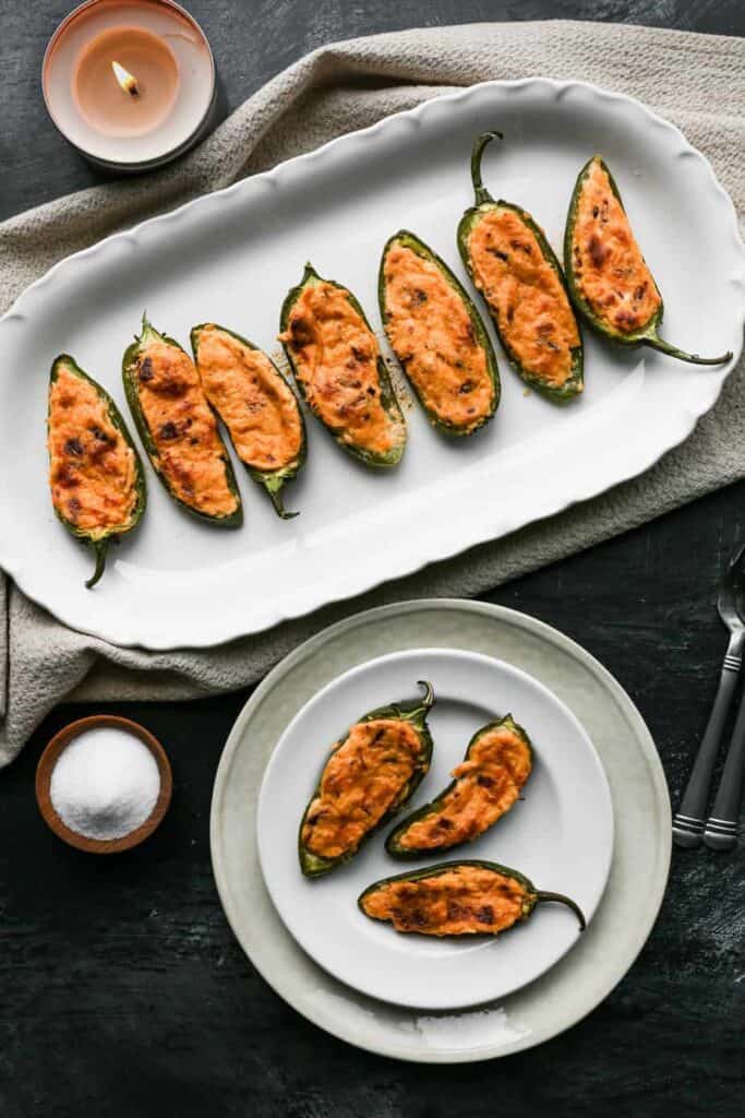 a white platter and white plate of gluten free jalapeño poppers