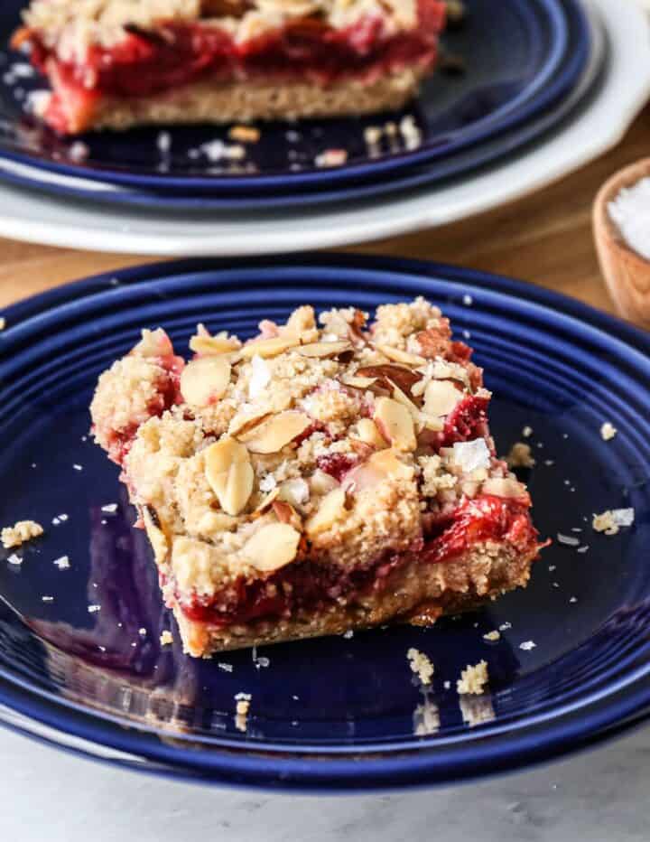 a blue plate with one gluten free strawberry rhubarb bar on it