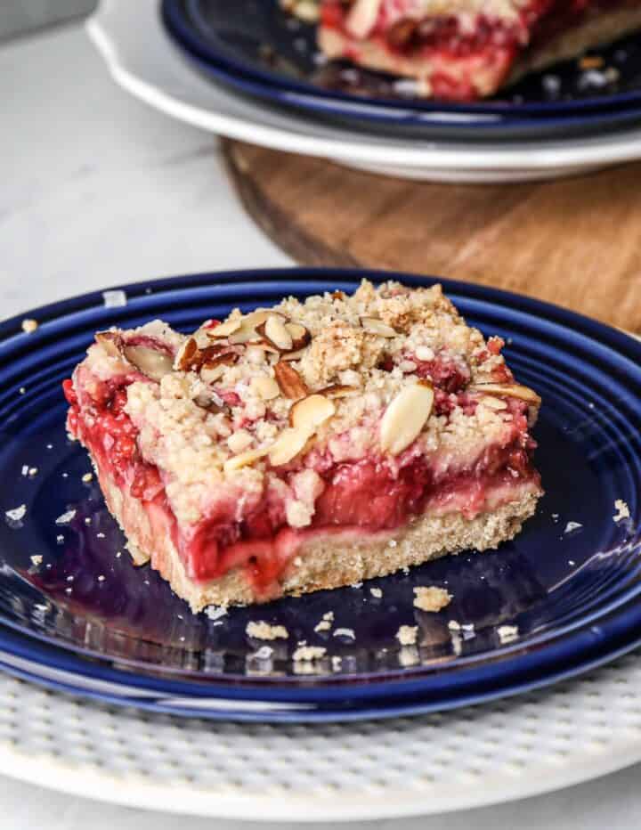 a blue plate with one gluten free strawberry rhubarb bar on it