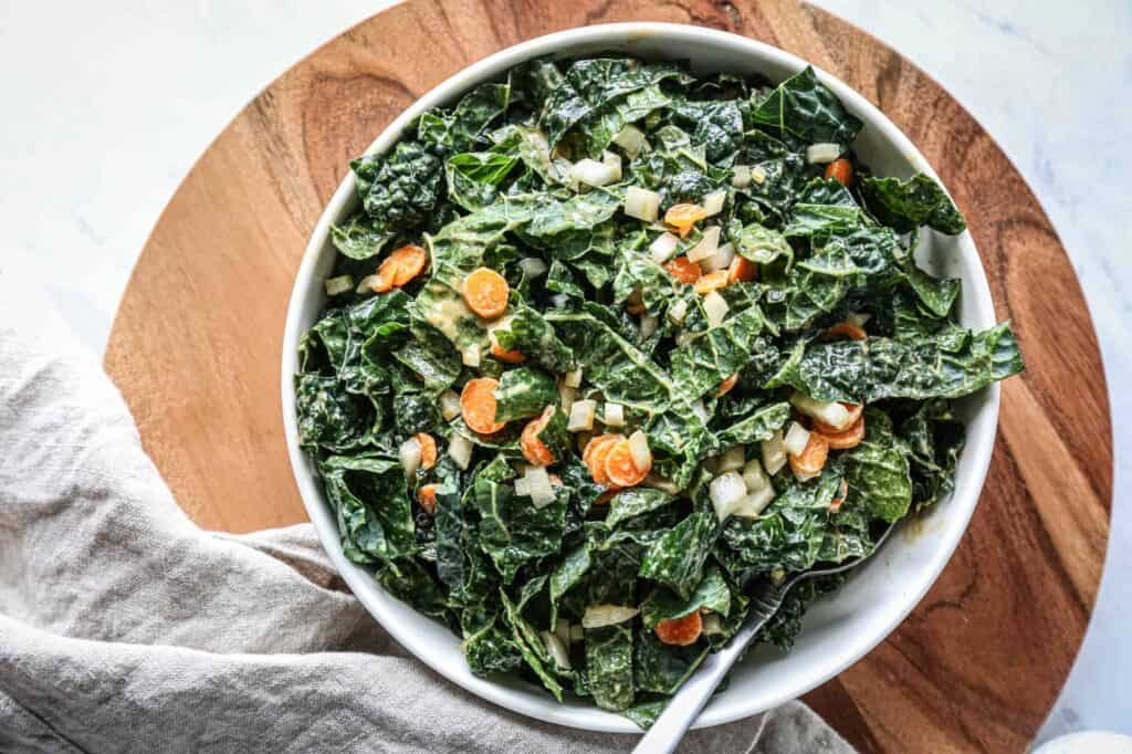 a large bowl of gluten free kale salad with peanut dressing
