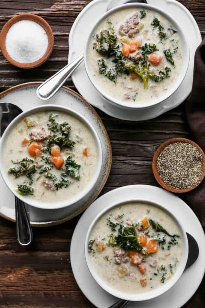 three white bowls of gluten free instant pot sausage and kale soup