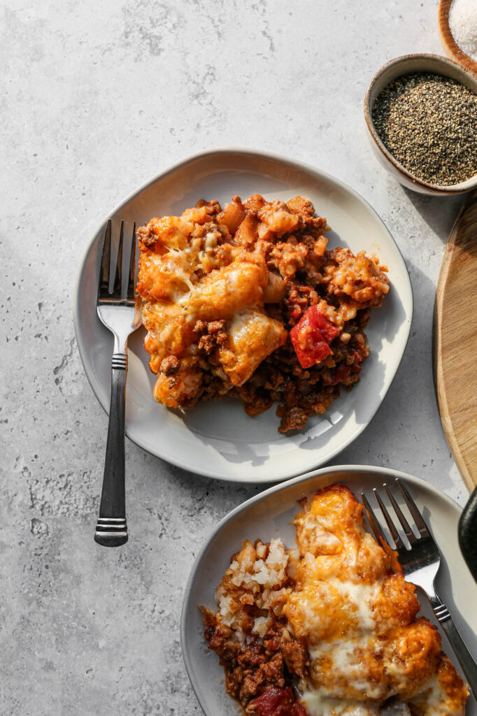 two white plates of gluten free cheesy tater tot casserole