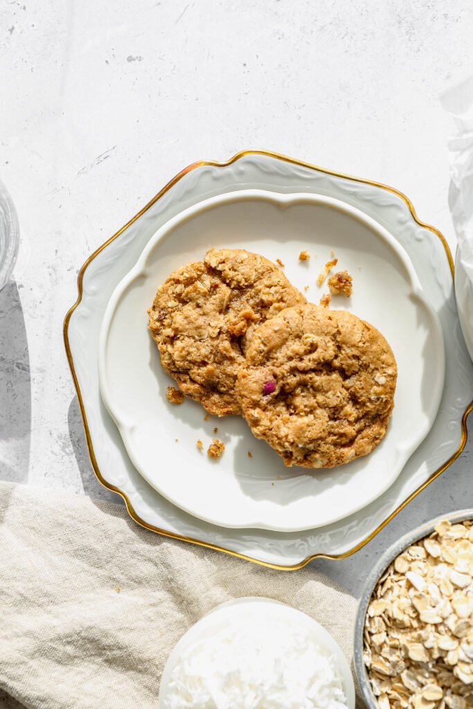 two gluten free monster cookies on a white plate.