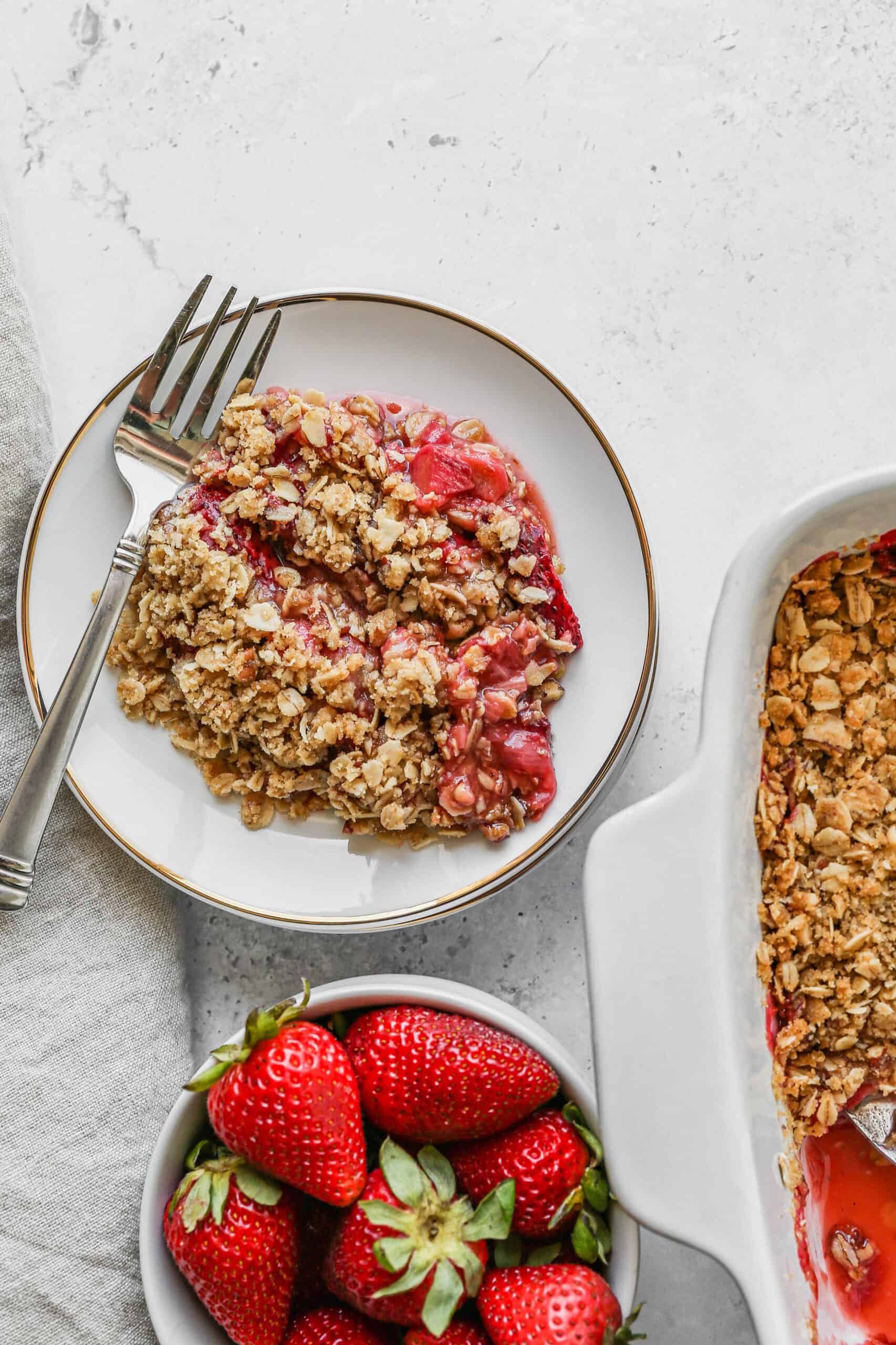 a white plate of gluten free strawberry rhubarb crumble.
