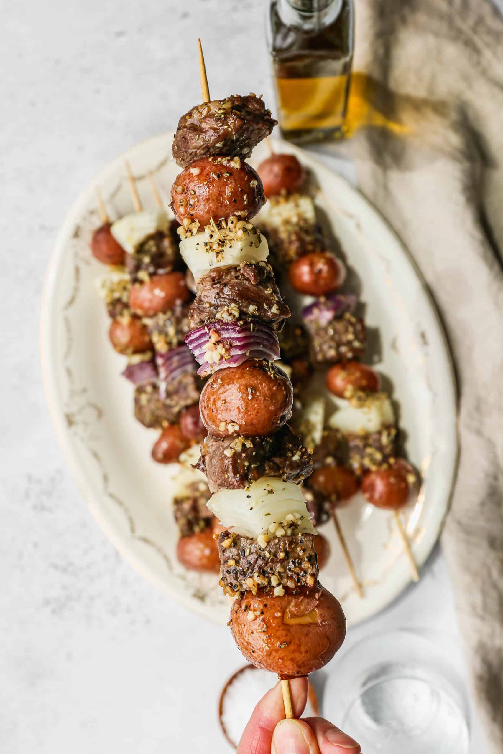 a wooden skewer of oven baked steak and potato kabobs.