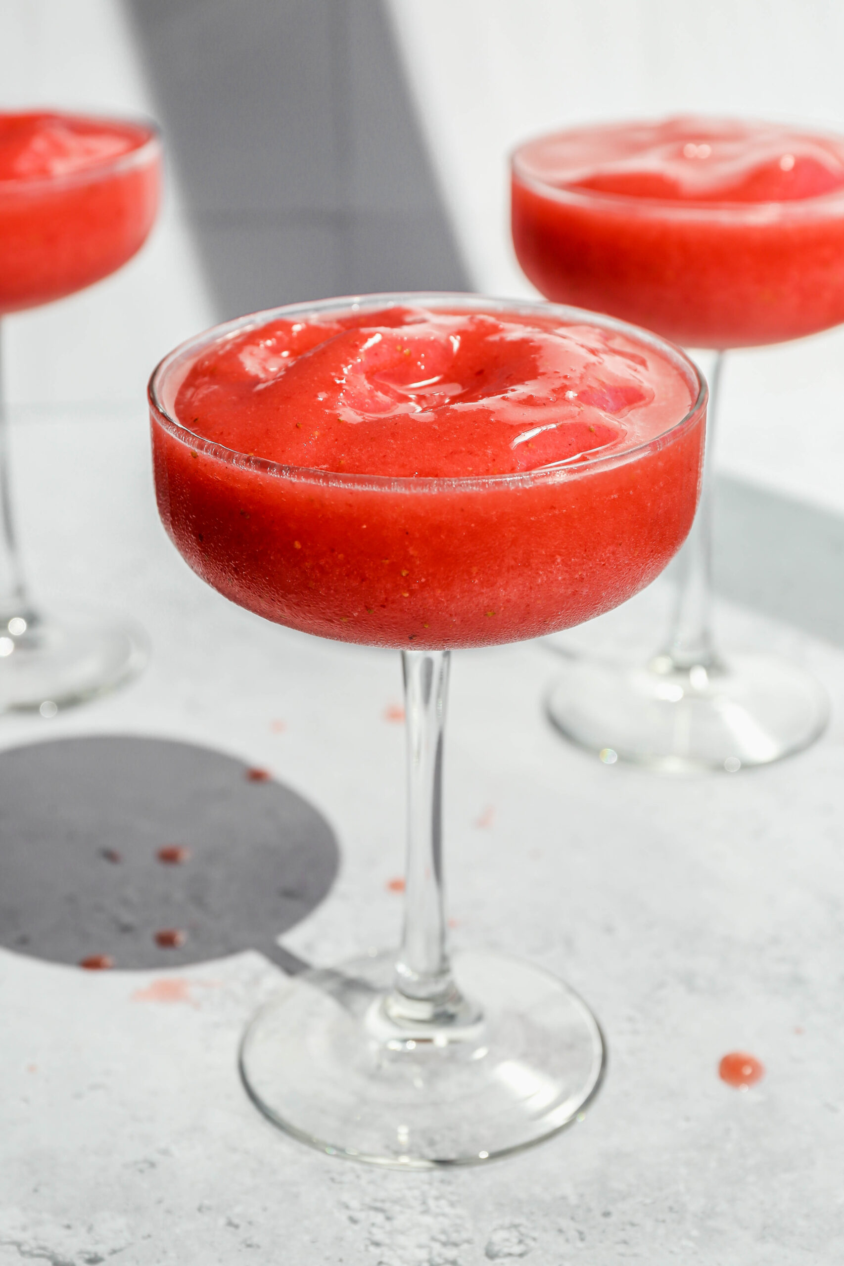 a long stemmed cocktail coupe of strawberry daiquiri mocktail.