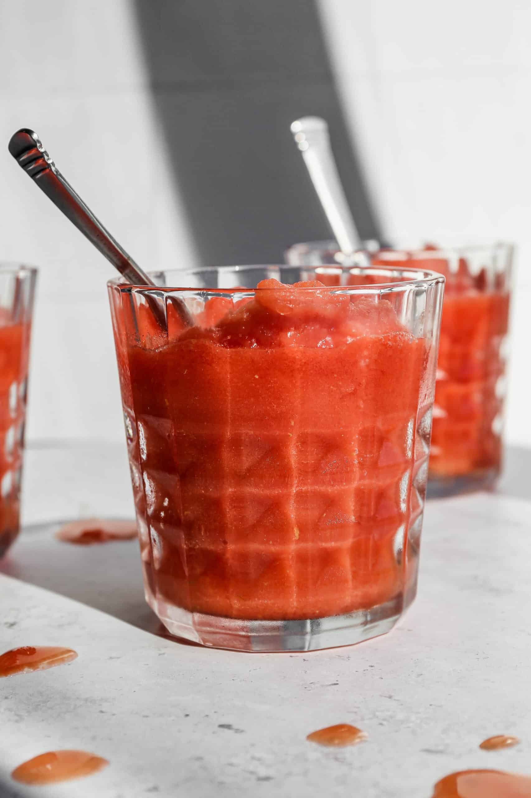 a glass tumbler of easy frozen watermelon margarita mocktail with a silver spoon in it.