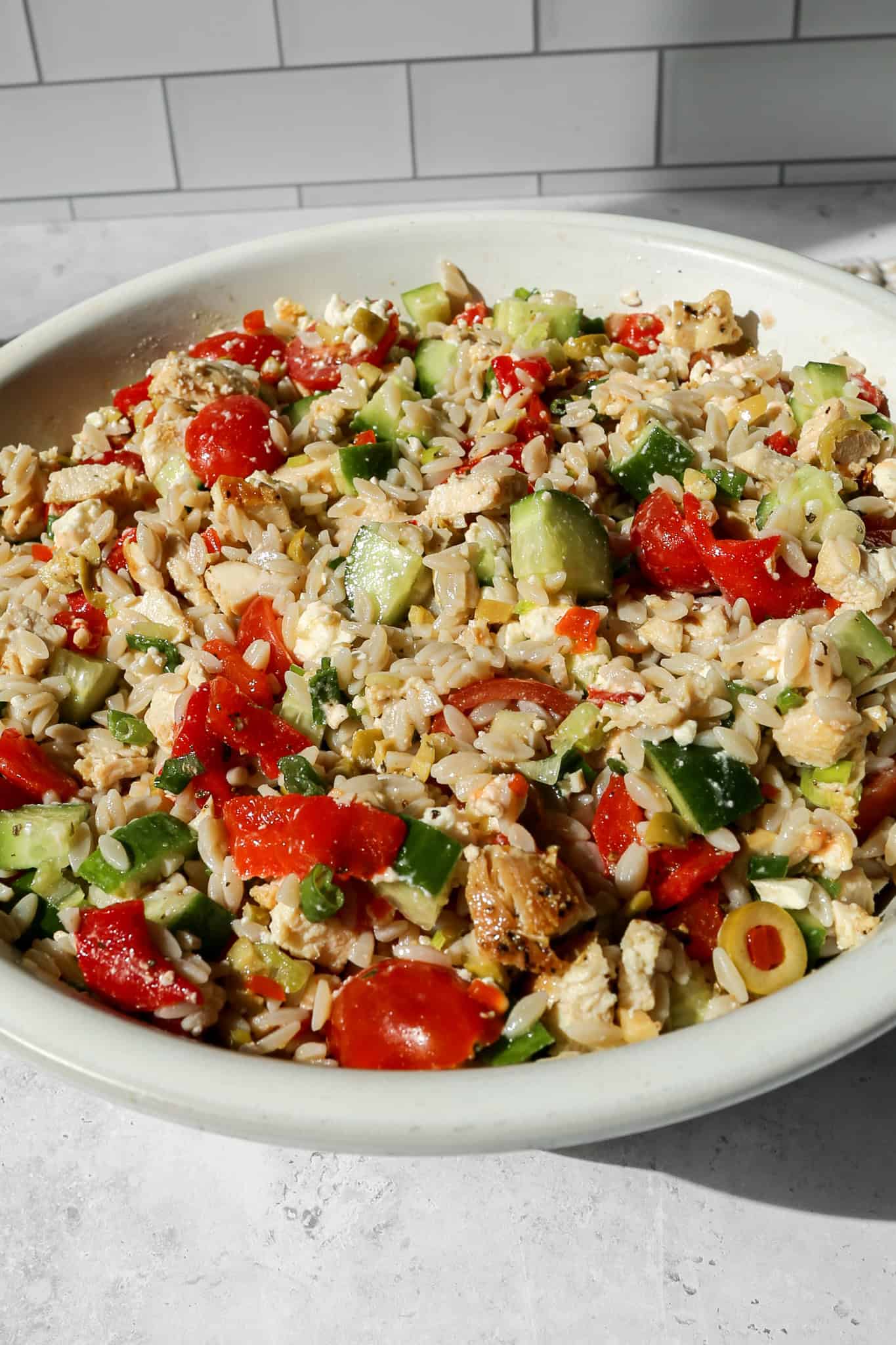 mediterranean chicken orzo salad in a white bowl