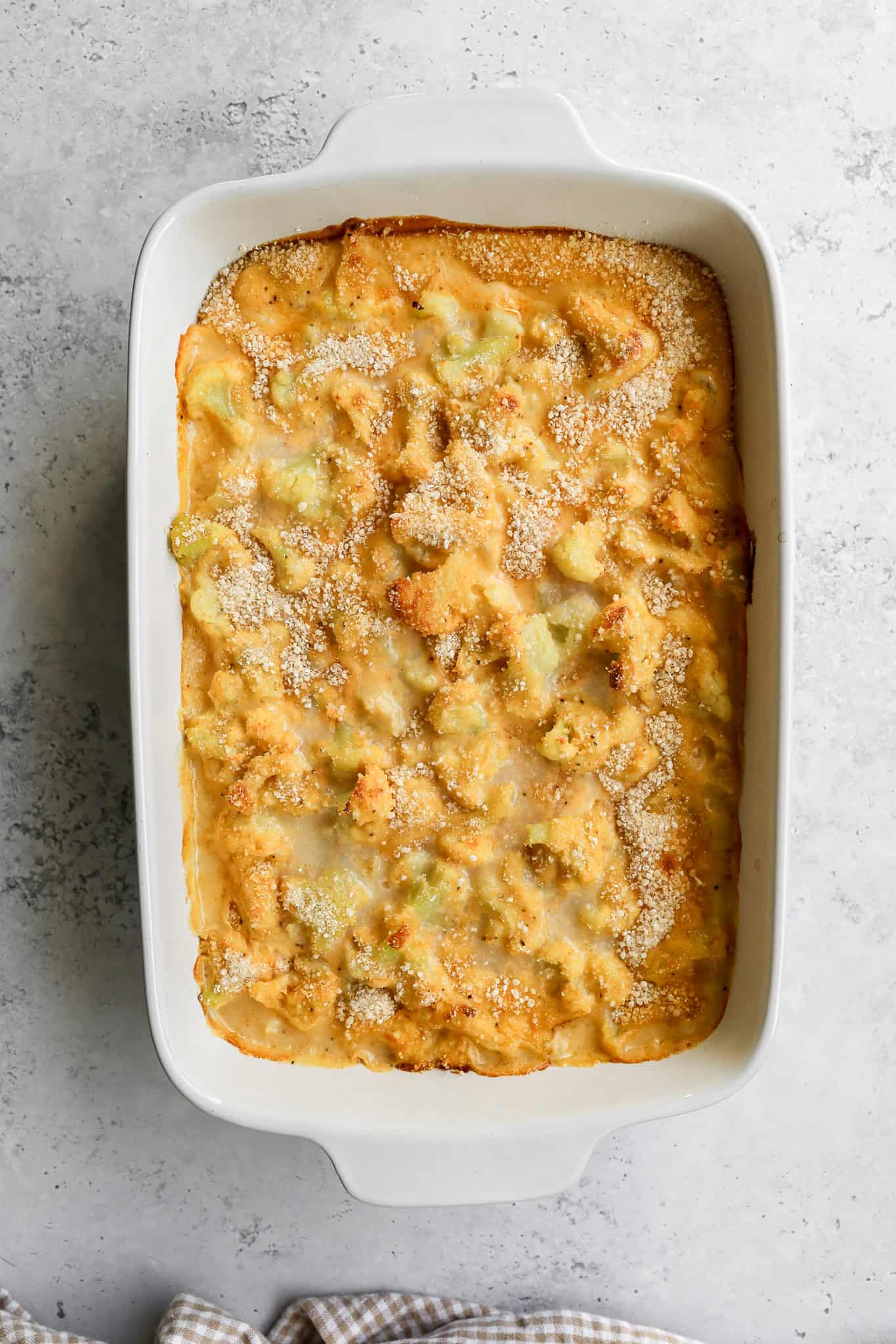 a white ceramic 9x13 baking dish of cheesy cauliflower casserole
