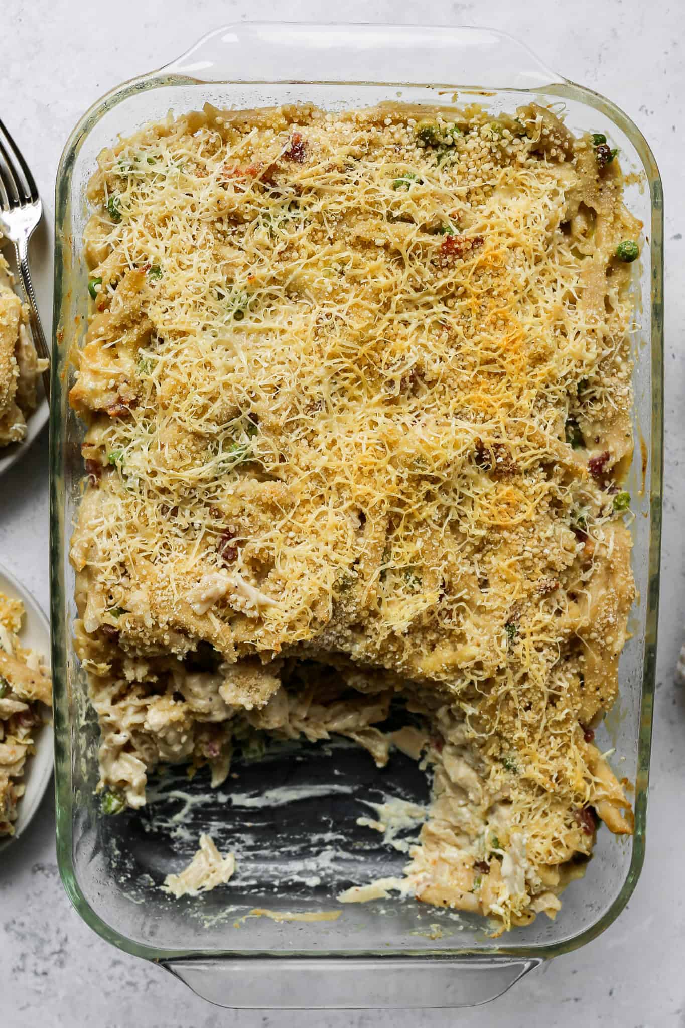 a clear glass 9x13 baking pan of gluten free chicken carbonara pasta bake