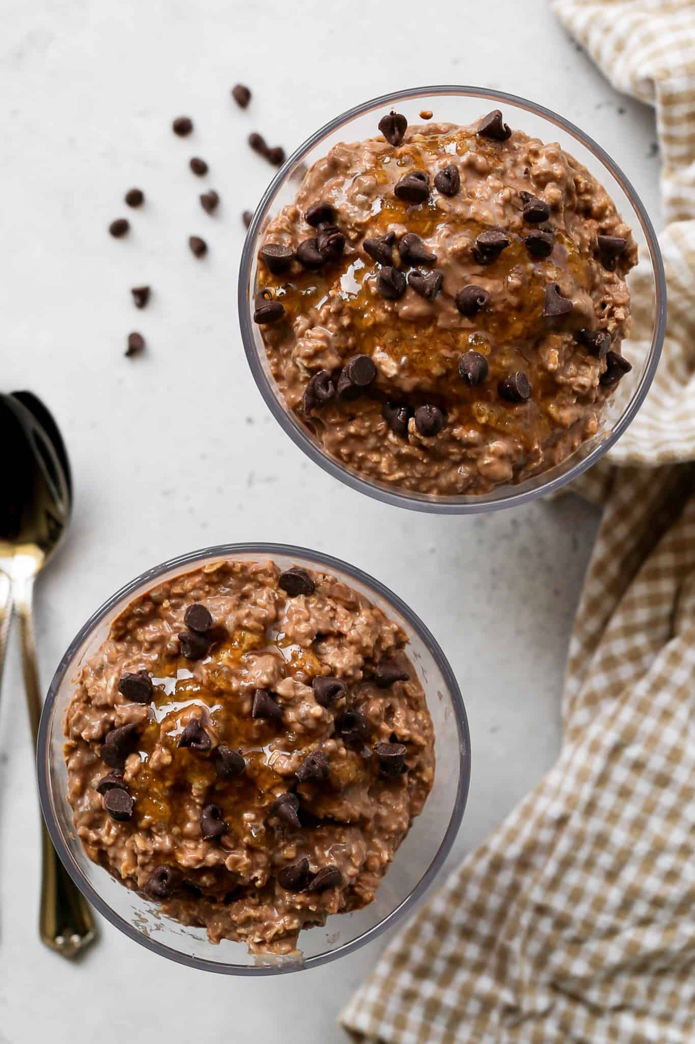 clear cups of high protein mocha overnight oats with honey drizzled on top and mini chocolate chips sprinkled on top