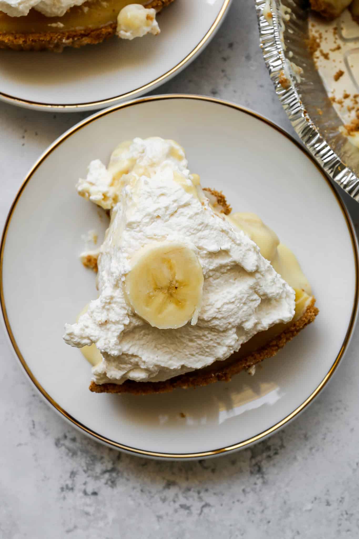 a slice of gluten free banana cream pie on a white plate with a gold trim